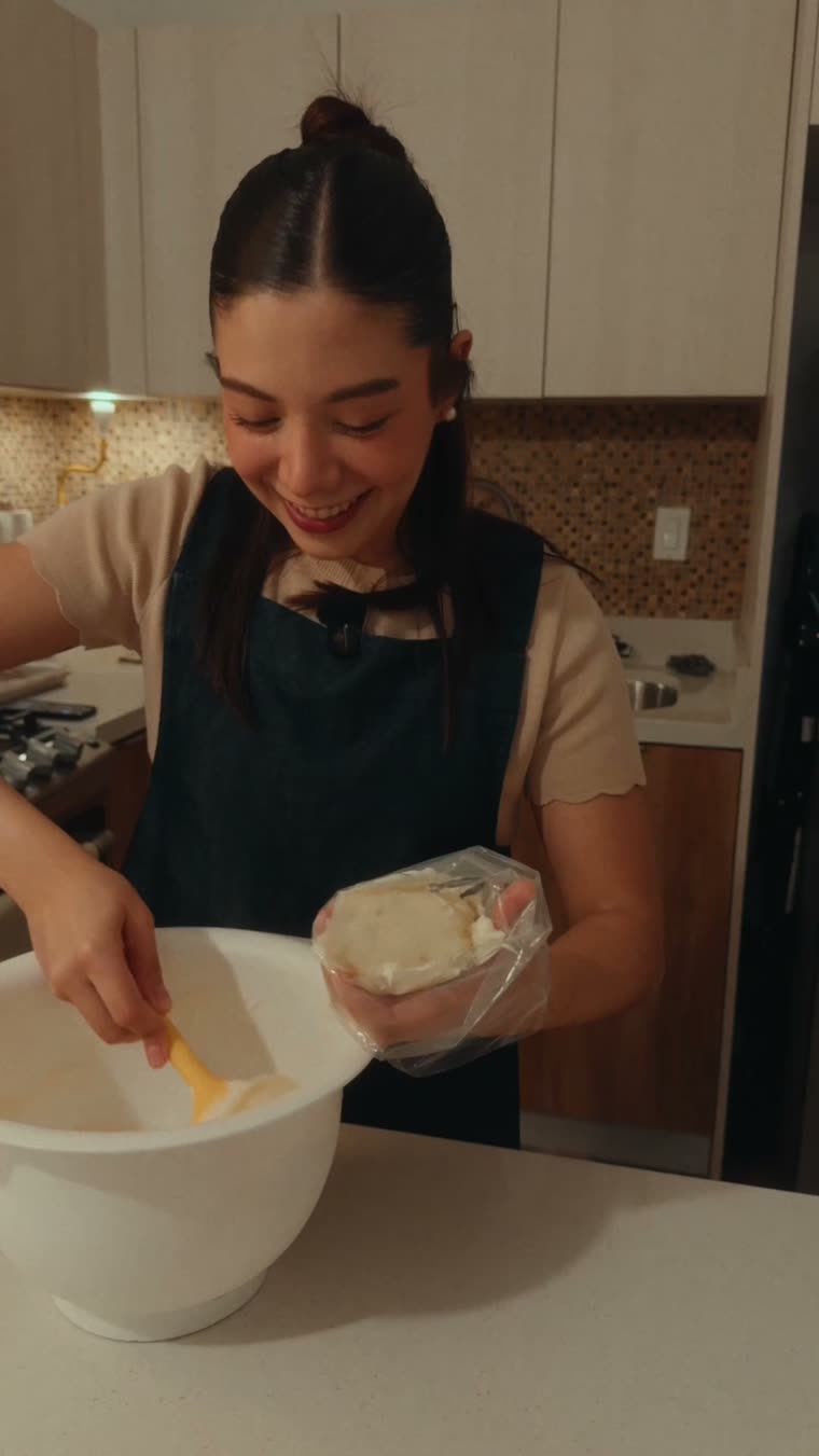 Marianna llena una bolsa para duya con el betún usando la espátula.