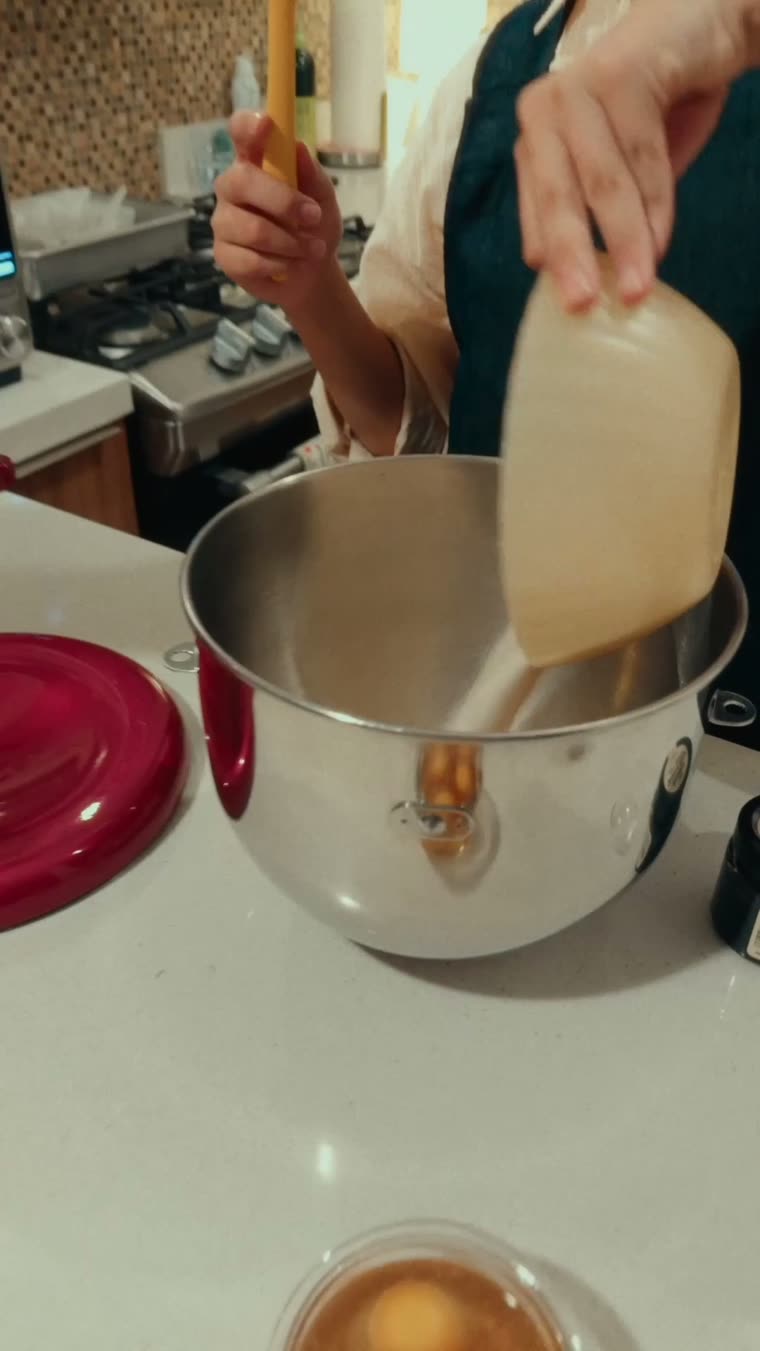 Marianna vacía el queso crema en el bowl de la batidora.