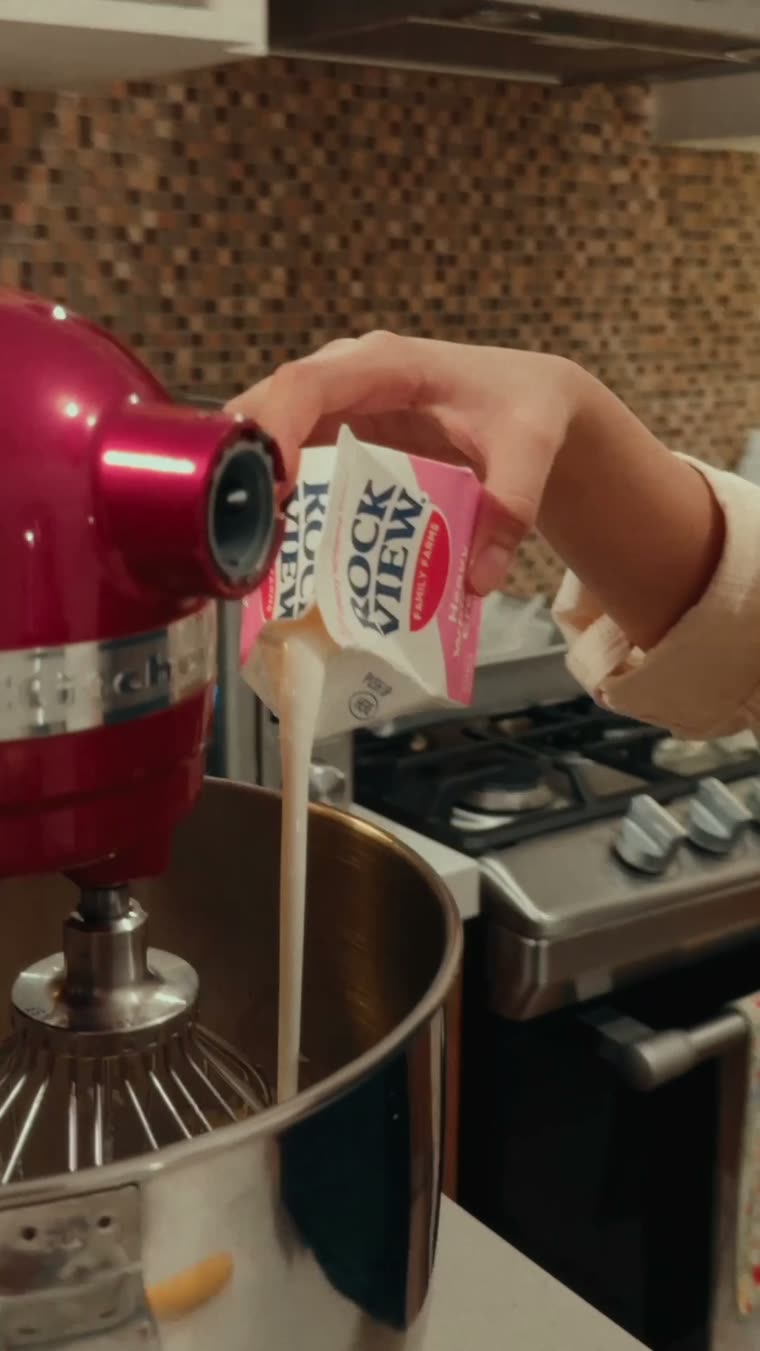 Marianna vierte la crema desde el cartón a la batidora.