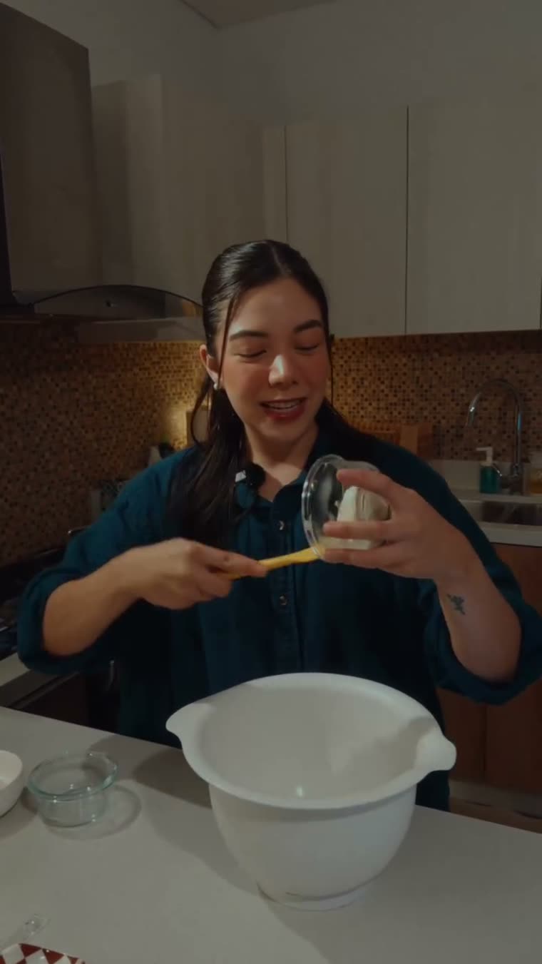 Marianna agrega el queso crema al tazón con la mantequilla.