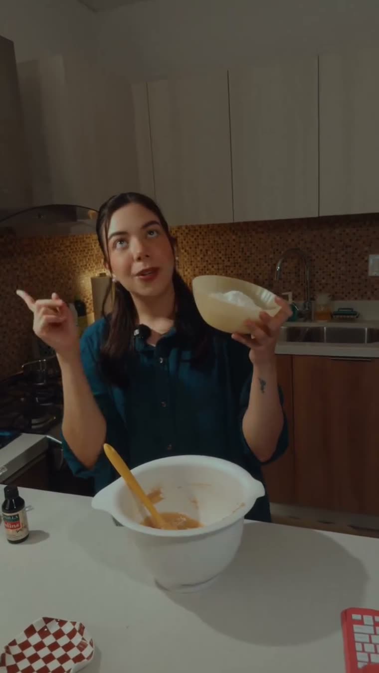 Marianna sostiene el tazón con los ingredientes secos sobre la masa.