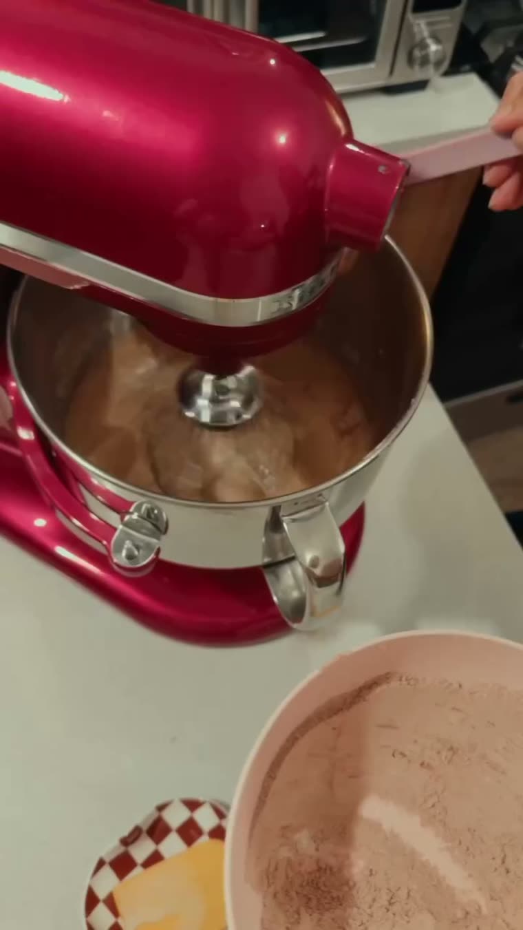 El tazón con la mezcla de chocolate y el recipiente de cocoa al lado.