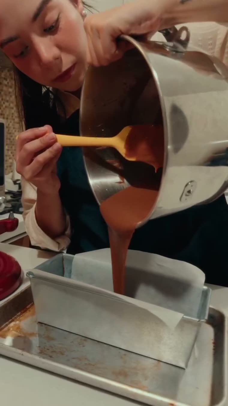 La mezcla de chocolate cae dentro del molde para panqué.
