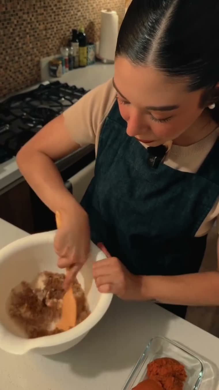 Marianna acrema el queso crema con el azúcar usando una espátula.